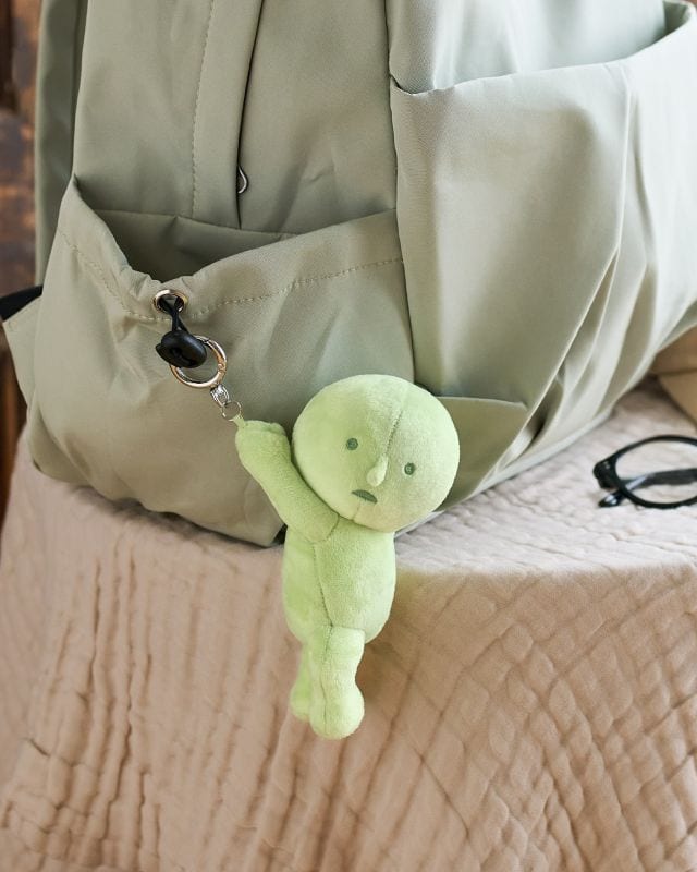 smiski plush keychain hanging from bag